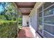 Covered side porch with tile flooring and lush hedges at 1802 E Hamilton Ave, Tampa, FL 33610