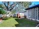 Landscaped backyard with a brick grill and mature trees at 1802 E Hamilton Ave, Tampa, FL 33610
