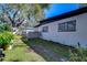 Backyard with grassy area, mature trees, and a partially visible fence at 1802 E Hamilton Ave, Tampa, FL 33610