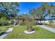 Mid-century modern home with carport and landscaped front yard at 1802 E Hamilton Ave, Tampa, FL 33610
