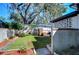 Landscaped backyard with a brick grill and mature trees at 1802 E Hamilton Ave, Tampa, FL 33610