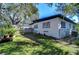 Large backyard with a grassy area and mature trees at 1802 E Hamilton Ave, Tampa, FL 33610