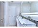 Modern bathroom with double sinks, marble countertops, and LED-lit mirror at 1802 E Hamilton Ave, Tampa, FL 33610