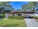 Mid-century modern home with carport and well-manicured lawn at 1802 E Hamilton Ave, Tampa, FL 33610