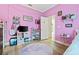 Small pink bedroom showcases laminate floors, whimsical decor, and closet at 1342 Salmonberry St, Wesley Chapel, FL 33543