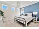 Bright bedroom with a metal bed frame, blue accent wall, and large windows at 31873 Anchor Point Dr, Wesley Chapel, FL 33545