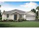 One-story home with light beige exterior, dark blue door, and two-car garage at 18440 Vista Park Ter, Venice, FL 34293
