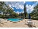 Community pool with lounge chairs and patio tables at 3581 Magnolia Ridge 802 # B, Palm Harbor, FL 34684