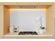 Modern gas cooktop with marble backsplash and wood cabinets at 1000 Water St # 1103, Tampa, FL 33602