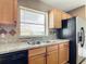 Kitchen with wood cabinets, granite countertops, and a double sink at 7518 Lyncrest St, North Port, FL 34287