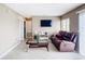 Living room features tiled floors, brown leather sofa, and a large flat-screen TV at 7518 Lyncrest St, North Port, FL 34287