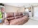 Bright living room with tiled floors, brown leather reclining sofa, and a coffee table at 7518 Lyncrest St, North Port, FL 34287