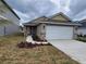 One story home with light brown siding, two-car garage, and small front yard at 36164 Trinity Glade Rd, Dade City, FL 33525