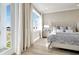 Main bedroom with king-size bed, water views, and private balcony at 31879 Anchor Point Dr, Wesley Chapel, FL 33545