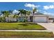 Single-story home with attached garage and lush landscaping at 6911 Greenbrier Dr, Seminole, FL 33777