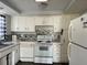 Small kitchen with white cabinets and appliances at 5323 Carlton Rd, New Port Richey, FL 34652