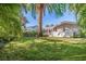 Landscaped backyard featuring a screened-in pool with a view of the beautiful lawn and foliage at 165 4Th N Ave, Tierra Verde, FL 33715