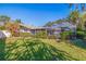 Beautiful backyard with manicured lawn, lush greenery, and a screened lanai at 165 4Th N Ave, Tierra Verde, FL 33715