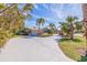 Beautiful home exterior with lush landscaping, palm trees, and a long driveway at 165 4Th N Ave, Tierra Verde, FL 33715