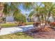 Inviting home exterior with lush landscaping, palm trees, and a well-maintained front yard at 165 4Th N Ave, Tierra Verde, FL 33715