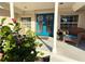 Charming front porch with blue doors, wicker seating, and lush plants at 165 4Th N Ave, Tierra Verde, FL 33715