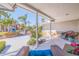 Relaxing front porch featuring wicker seating with blue accents, lush plants, and a view of the beautiful landscaped yard at 165 4Th N Ave, Tierra Verde, FL 33715