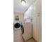 Well-organized laundry room equipped with modern washer and dryer units, and ample white cabinet storage for laundry essentials at 165 4Th N Ave, Tierra Verde, FL 33715