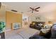 Cozy living room with carpet flooring, ceiling fan, and an decorative cabinet at 165 4Th N Ave, Tierra Verde, FL 33715