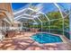 Relaxing screened outdoor pool area featuring a dining set, grill, lounge chairs and luscious landscaping at 165 4Th N Ave, Tierra Verde, FL 33715