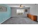Bedroom with a blue accent wall, standard ceiling fan, dresser, and a large window at 2857 Brewster Rd, North Port, FL 34288
