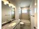 Bathroom features granite vanity, toilet and tiled shower over tub combo with window at 31895 Anchor Point Dr, Wesley Chapel, FL 33545