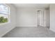 Neutral bedroom featuring soft gray carpet, freshly painted walls, and a window with pleasant outside views at 31895 Anchor Point Dr, Wesley Chapel, FL 33545