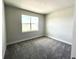 Bedroom featuring gray carpet, neutral walls and a large window at 31895 Anchor Point Dr, Wesley Chapel, FL 33545