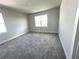 A bright, carpeted bedroom with two large windows offering plenty of natural light at 31895 Anchor Point Dr, Wesley Chapel, FL 33545