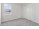 Well-lit bedroom features gray carpet, a window, and a closet at 31895 Anchor Point Dr, Wesley Chapel, FL 33545