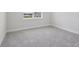 Neutrally decorated bedroom featuring carpeted floors and views of neighborhood amenities from the window at 31895 Anchor Point Dr, Wesley Chapel, FL 33545