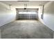 Interior view of an empty two car garage with concrete floor and paneled garage door at 31895 Anchor Point Dr, Wesley Chapel, FL 33545