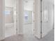 Hallway view of a bathroom with tiled tub and a bedroom with natural light from the windows at 31895 Anchor Point Dr, Wesley Chapel, FL 33545