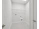 Simple, tidy laundry room with tile floor, wire shelving, and modern hookups for laundry machines at 31895 Anchor Point Dr, Wesley Chapel, FL 33545