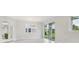 Bright open-concept living room with tile floors, white trim, and large glass windows with a view at 31895 Anchor Point Dr, Wesley Chapel, FL 33545