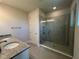 Bathroom featuring double sinks with granite counters and a glass-enclosed walk-in shower at 31901 Anchor Point Dr, Wesley Chapel, FL 33545