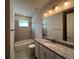 Well-lit bathroom featuring a granite countertop vanity and a shower-tub combo at 31901 Anchor Point Dr, Wesley Chapel, FL 33545