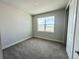 Cozy bedroom featuring neutral walls, soft carpeting, and a bright window with a pleasant outdoor view at 31901 Anchor Point Dr, Wesley Chapel, FL 33545