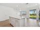 Open-concept kitchen showcasing white cabinetry, quartz countertops, and sliding glass doors to the backyard at 6741 Michael Favor Way, Wesley Chapel, FL 33545