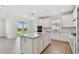 Spacious kitchen featuring a center island, white cabinets, stainless steel appliances, and backyard views at 6741 Michael Favor Way, Wesley Chapel, FL 33545
