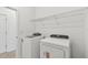 Functional laundry room featuring modern appliances, a wire shelf, and ample storage space at 6741 Michael Favor Way, Wesley Chapel, FL 33545