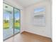 Bright room with sliding glass doors leading to an outdoor patio and a large window with blinds at 6741 Michael Favor Way, Wesley Chapel, FL 33545