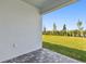 View of the home's outdoor patio with stone pavers, overlooking the well-maintained backyard at 6741 Michael Favor Way, Wesley Chapel, FL 33545