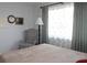 Bedroom with a plaid chair, floor lamp, and beige bedding at 4460 95Th N Ave # 1, Pinellas Park, FL 33782