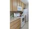 Well-equipped kitchen with white appliances and wood cabinets at 4460 95Th N Ave # 1, Pinellas Park, FL 33782